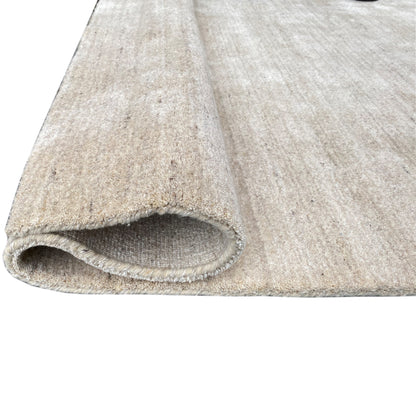 Detailed view: beige rug with the underside visible at the rolled edge