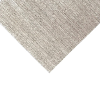 Beige rectangular rug with a subtle mottled pattern shown in diagonal perspective