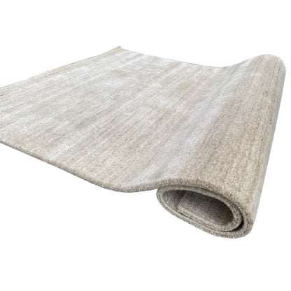 Beige rolled-up carpet; visible edge and mottled pile surface