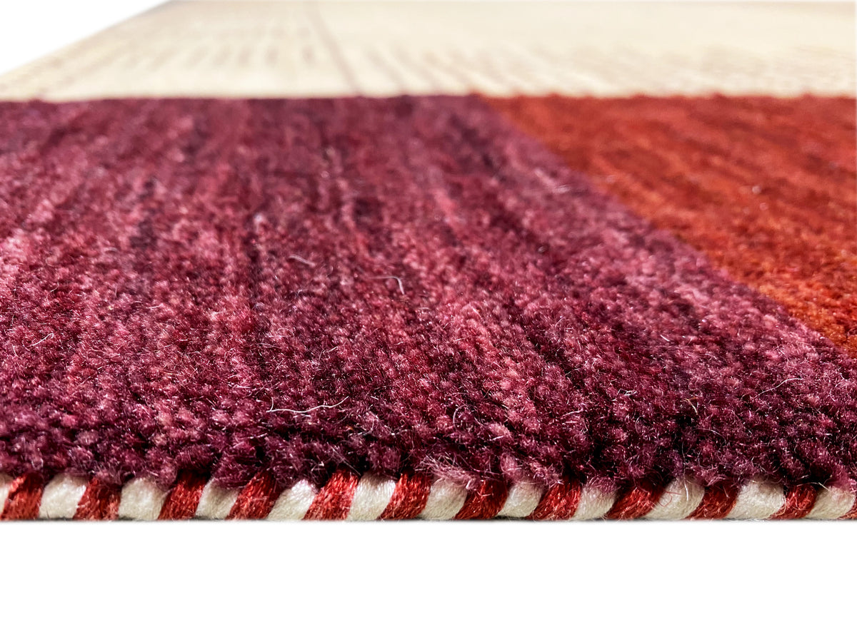 Teppich mit hochflorigem, dunkelrotem Flor und sichtbarer Rücken-/Saumkante