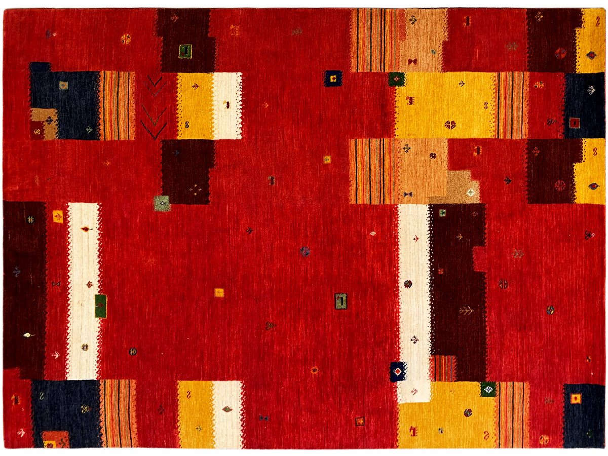 Loom Luri Teppich Nahaufnahme: rotes Patchwork mit gelben, weißen und dunkelblauen Einsätzen