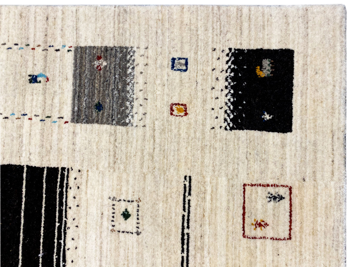 Nahaufnahme Loom Luri-Teppich: beige Oberfläche mit schwarz und bunten Musterquadraten