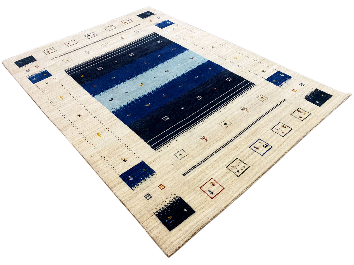 Loom Luri Teppich im schrägen Blick: beiges Design mit blauem Zentrum