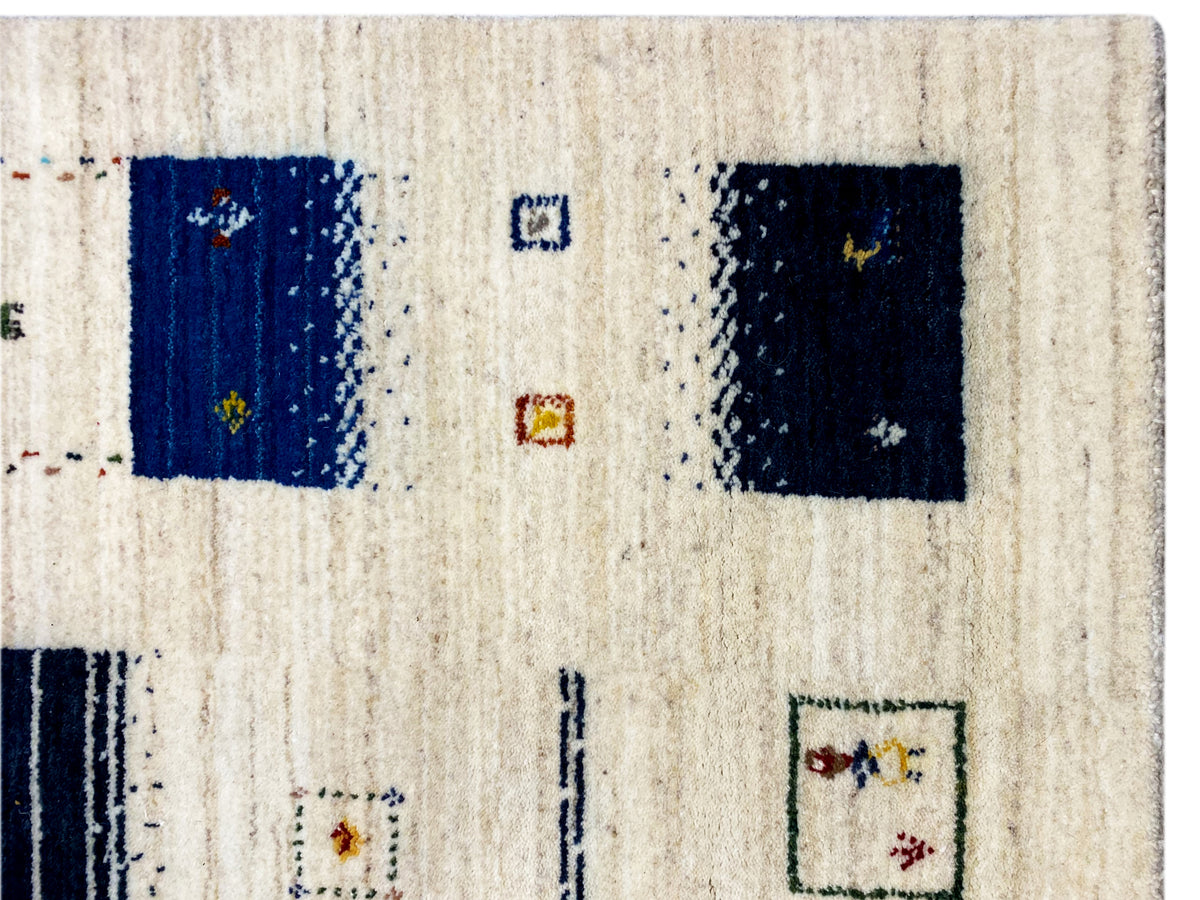 Loom Luri Teppich Nahaufnahme: beiger Flor mit dunkelblauen Quadraten und Zeichen
