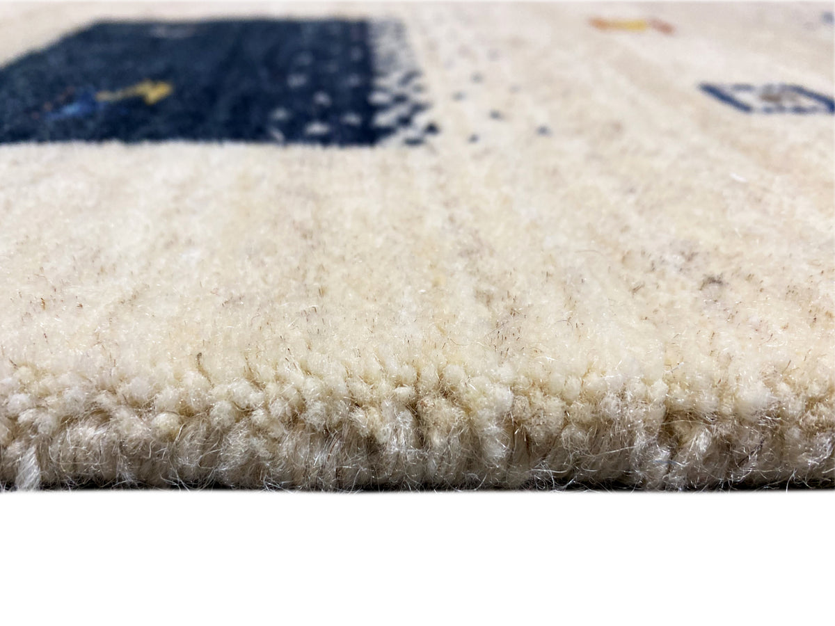 Loom Luri Teppich Detail Nahaufnahme vom Flor, beiger Teppich mit Blau im Hintergrund