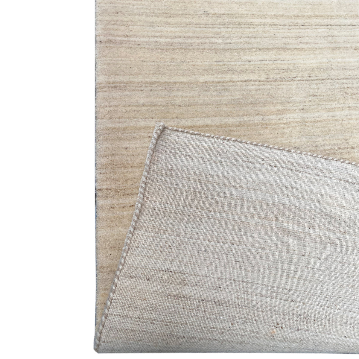 Natural gabbeh rug, detail of overlock stitching along the rug edge, light beige