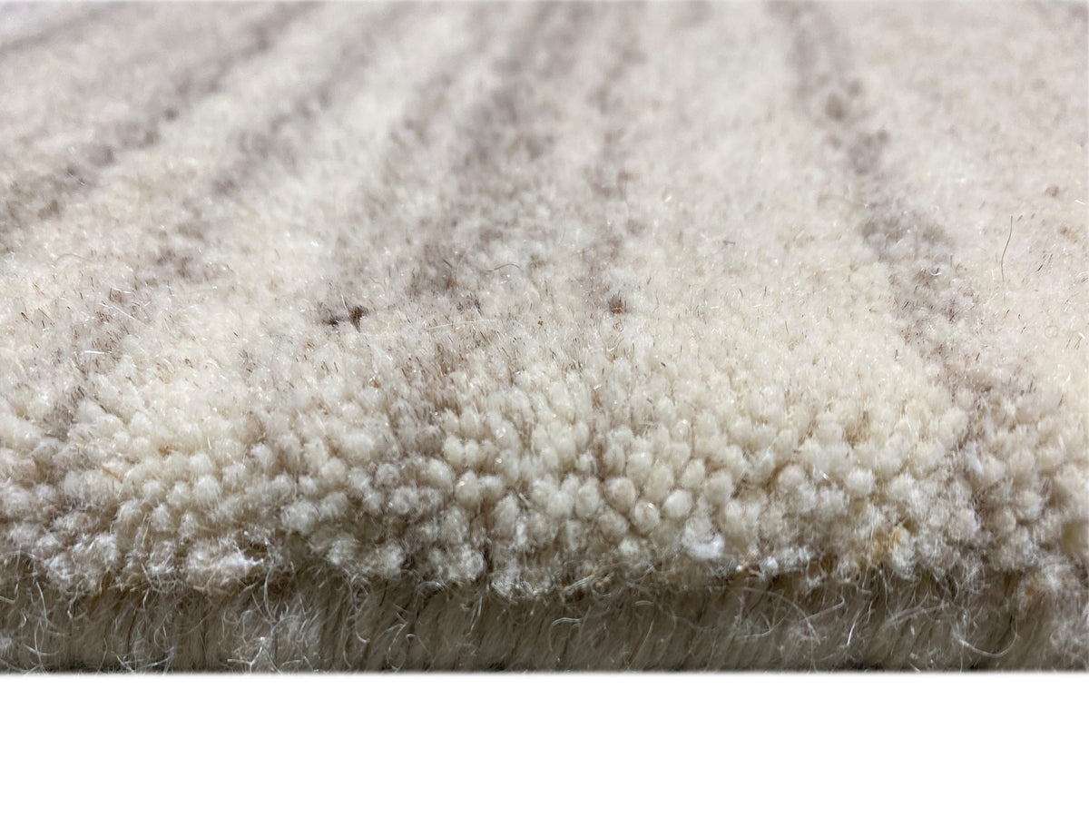 Gabbeh-Loom-Teppich: dichter Flor in hellem Offwhite, feine Faserstruktur im Detail.