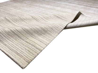 Gabbeh-Loom-Teppich mit sichtbarer Kante und zurückgeschlagenem Rand, hellbeige.