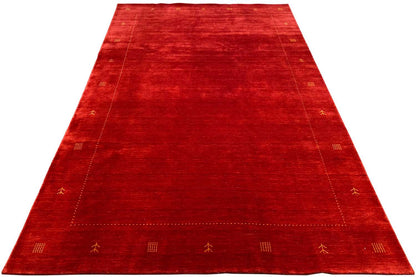 Red rug with a wide central section and subtle ornamental border, rectangular