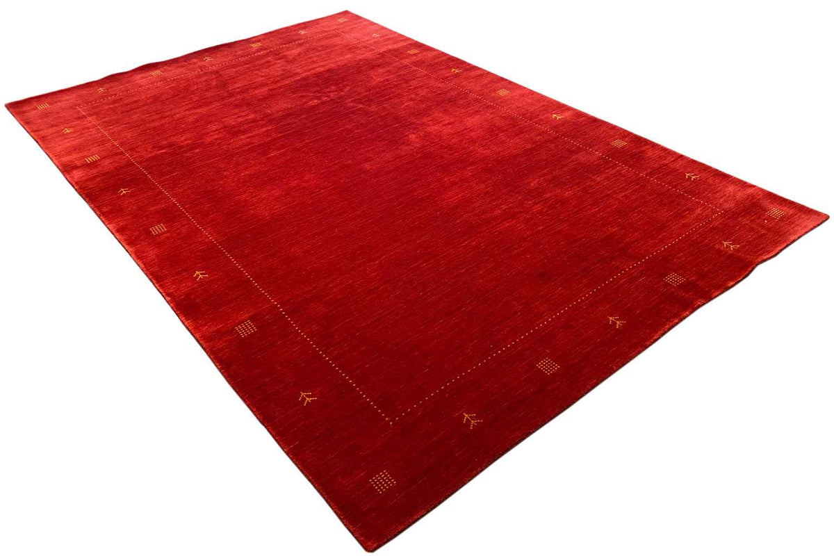 Red carpet laid diagonally, with a fine textured weave and small ornaments