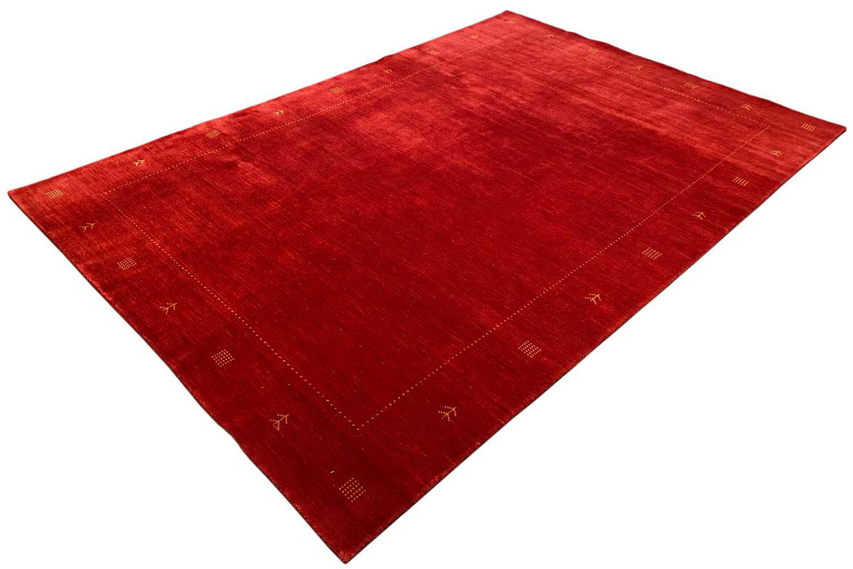 Red carpet spread diagonally, with a geometric border and symbolic motifs