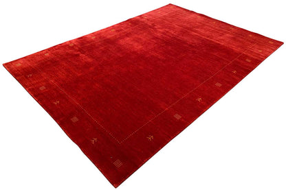Red carpet spread diagonally, with a geometric border and symbolic motifs