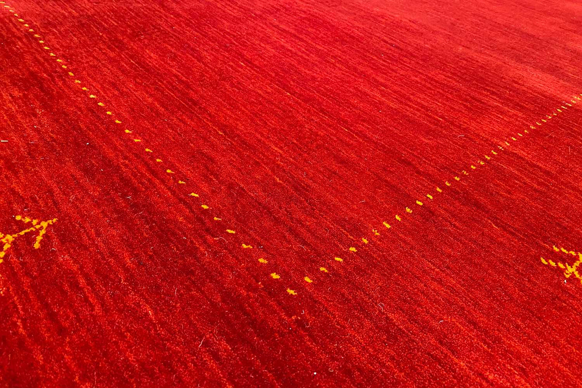 Detailed view: red carpet with yellowish lines and dot ornaments in the weave pattern