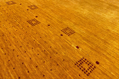 Gabbeh rug detail view: honey-brown surface with dark square motifs