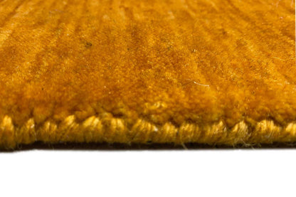 Gabbeh rug close-up: honey-brown pile with a visible rug edge
