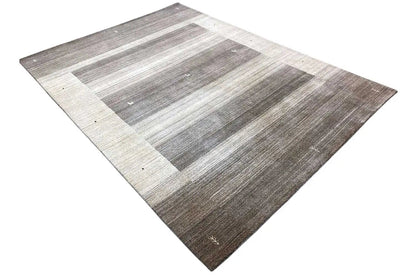 Rug in a diamond pattern with gray and beige stripes and a clearly defined light central area.