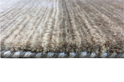 Carpet edge with short mottled pile in gray and beige, visible pile finish.