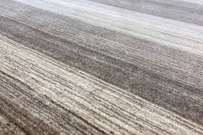 Carpet surface with fine horizontal lines and dense, short pile in gray and beige.