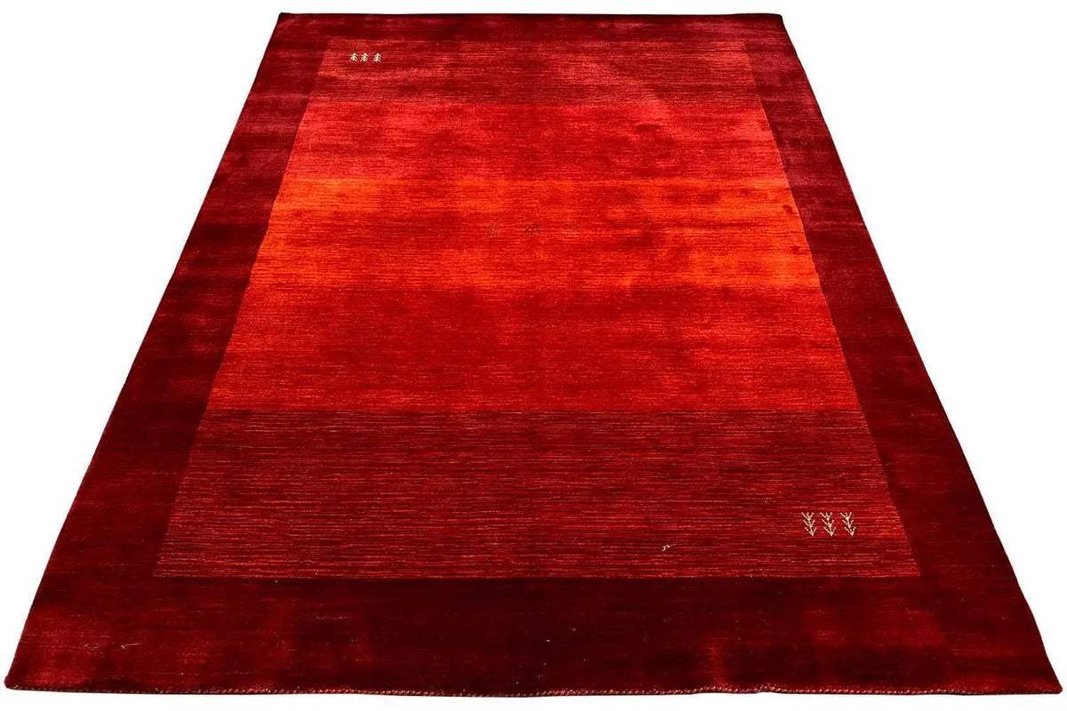Overview of a red Gabbeh rug with narrow borders and an even pattern.
