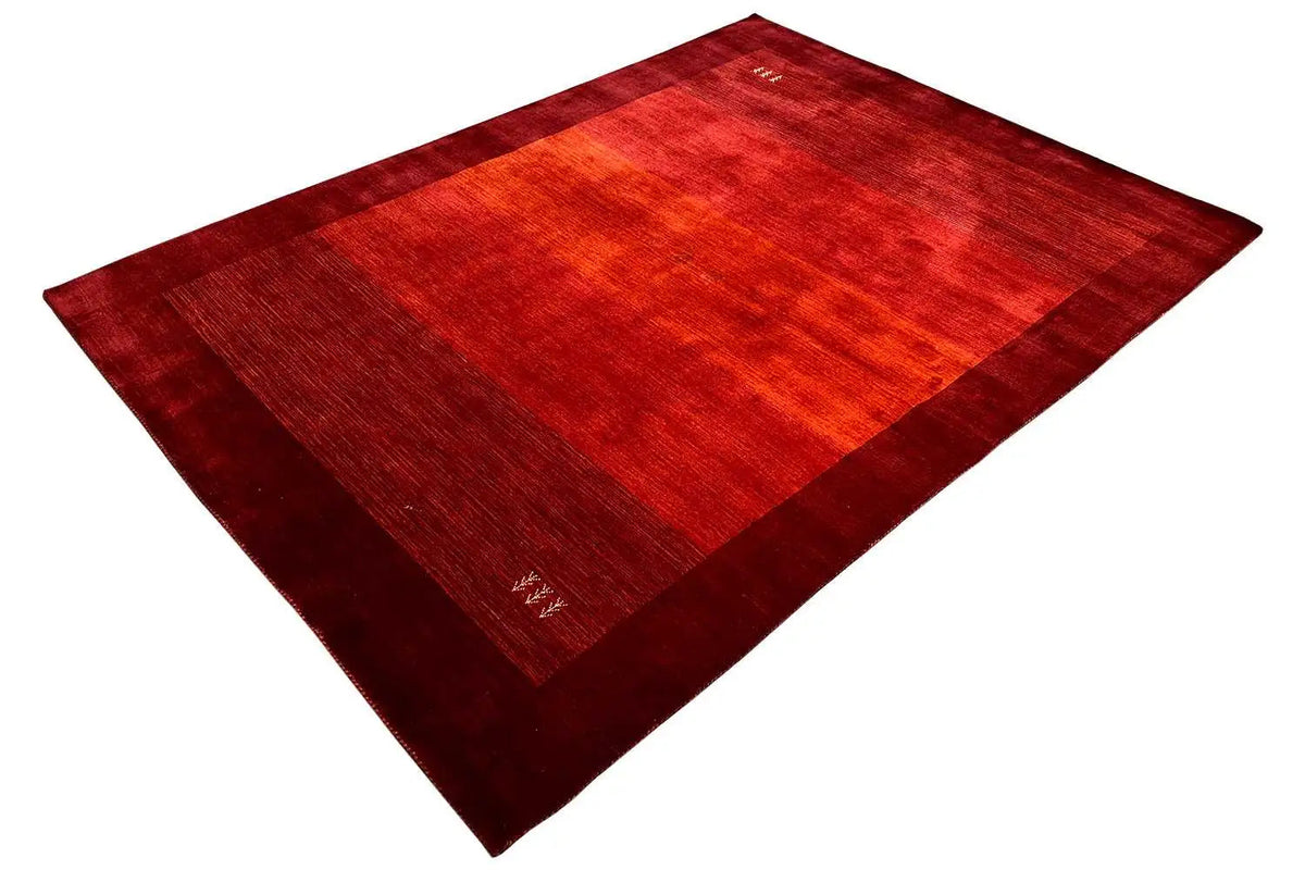 Red Gabbeh rug, angled view with colored block areas and a clean edge.