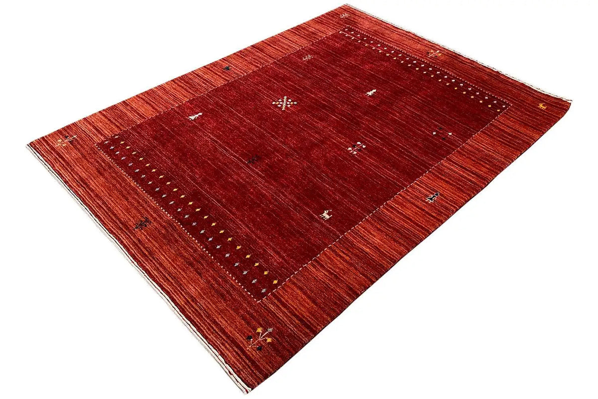 Gabbeh rug, dark red field with a delicate border in angled view