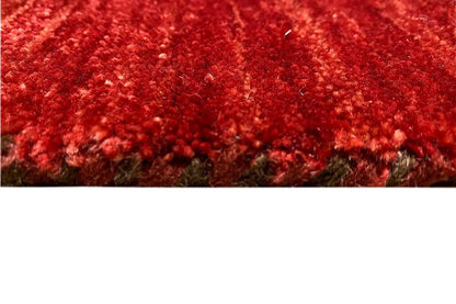Close-up of the Gabbeh rug: dense red pile with fine grain and dark edges