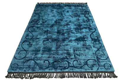 Blue Gabbeh rug in triangular view, with fringes all around and an ornamental border