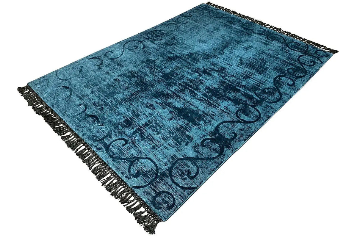Blue carpet with twisted ornaments and a surrounding fringe border, angled