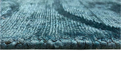 Close-up: blue carpet edge with a dense weave and short fringes