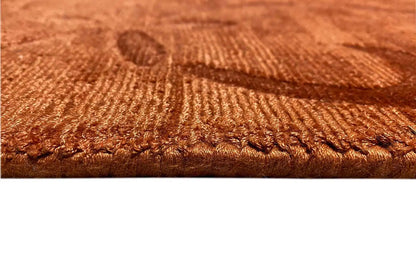 Gabbeh rug detail: rust-brown woven texture with fringes along the rug’s edge