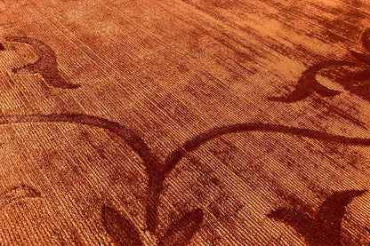 Gabbeh rug detail: rust-brown relief with a floral vine pattern