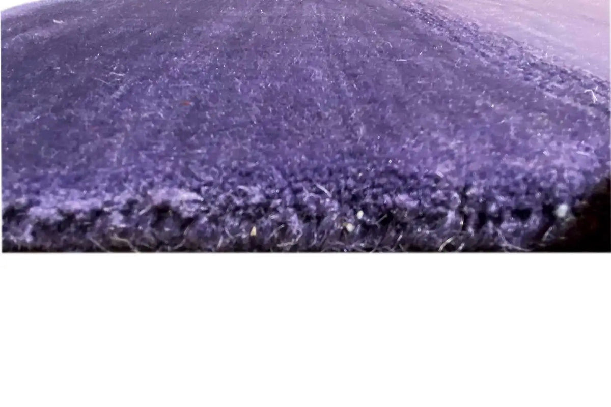Gabbeh rug close-up: pile and edge with a fine fringed finish, purple.