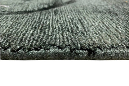 Close-up: dark green Gabbeh rug with a dense pile and blue fringes
