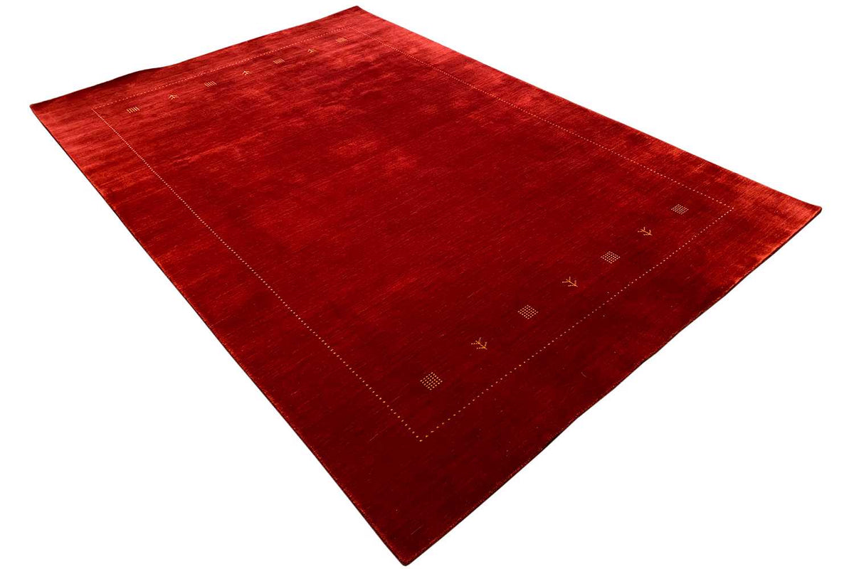 Gabbeh rug in dark red with a delicate pattern and an ornamented border area near the edge
