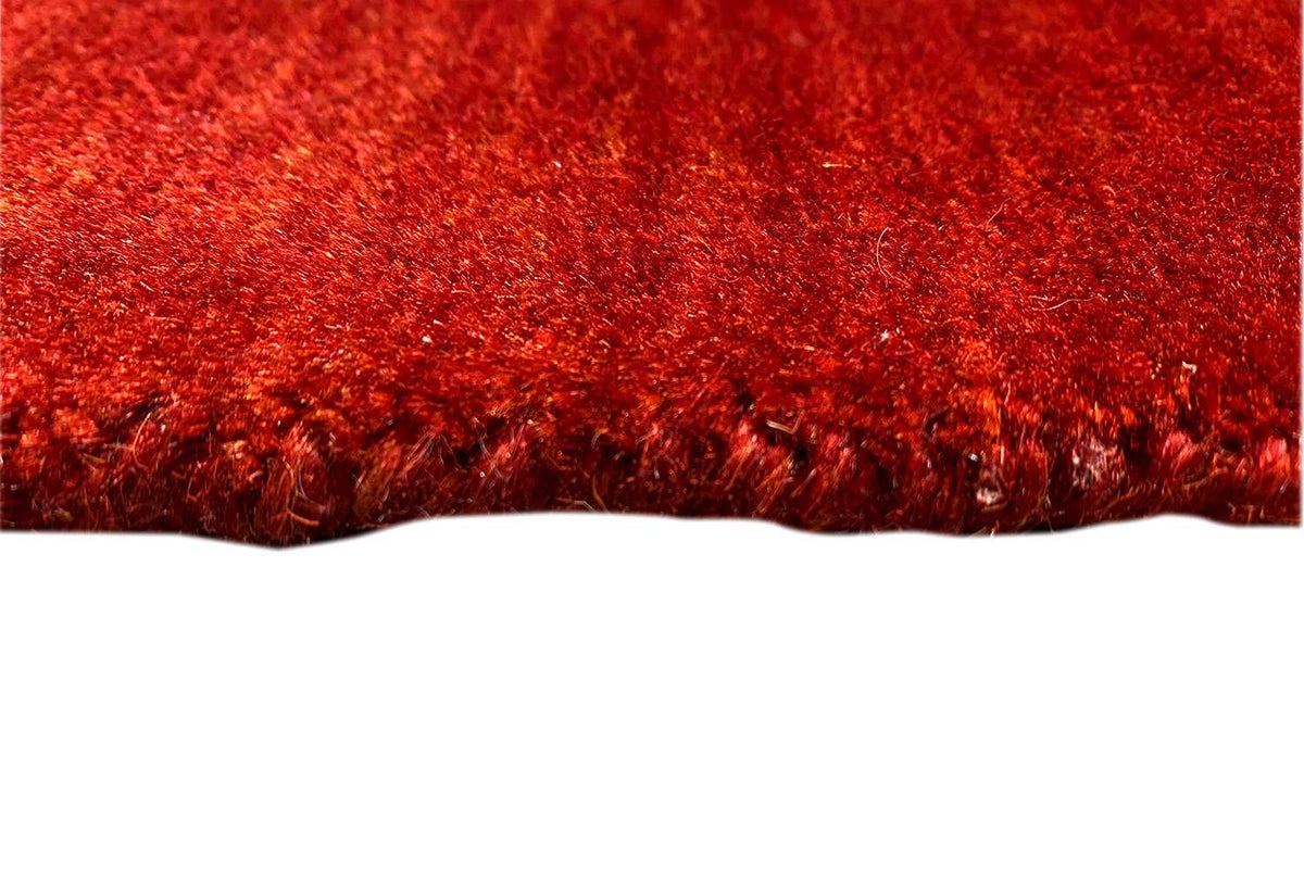 Red Gabbeh rug with a dense pile and visible edge