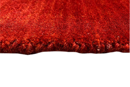Red Gabbeh rug with a dense pile and visible edge
