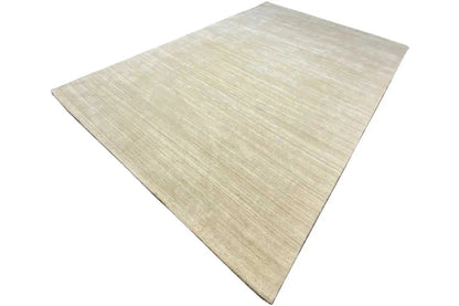 Gabbeh rug in light beige with a fine linear texture, laid at an angle