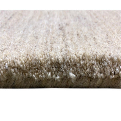 Close-up of the carpet edge with short, beige pile and an even upright texture