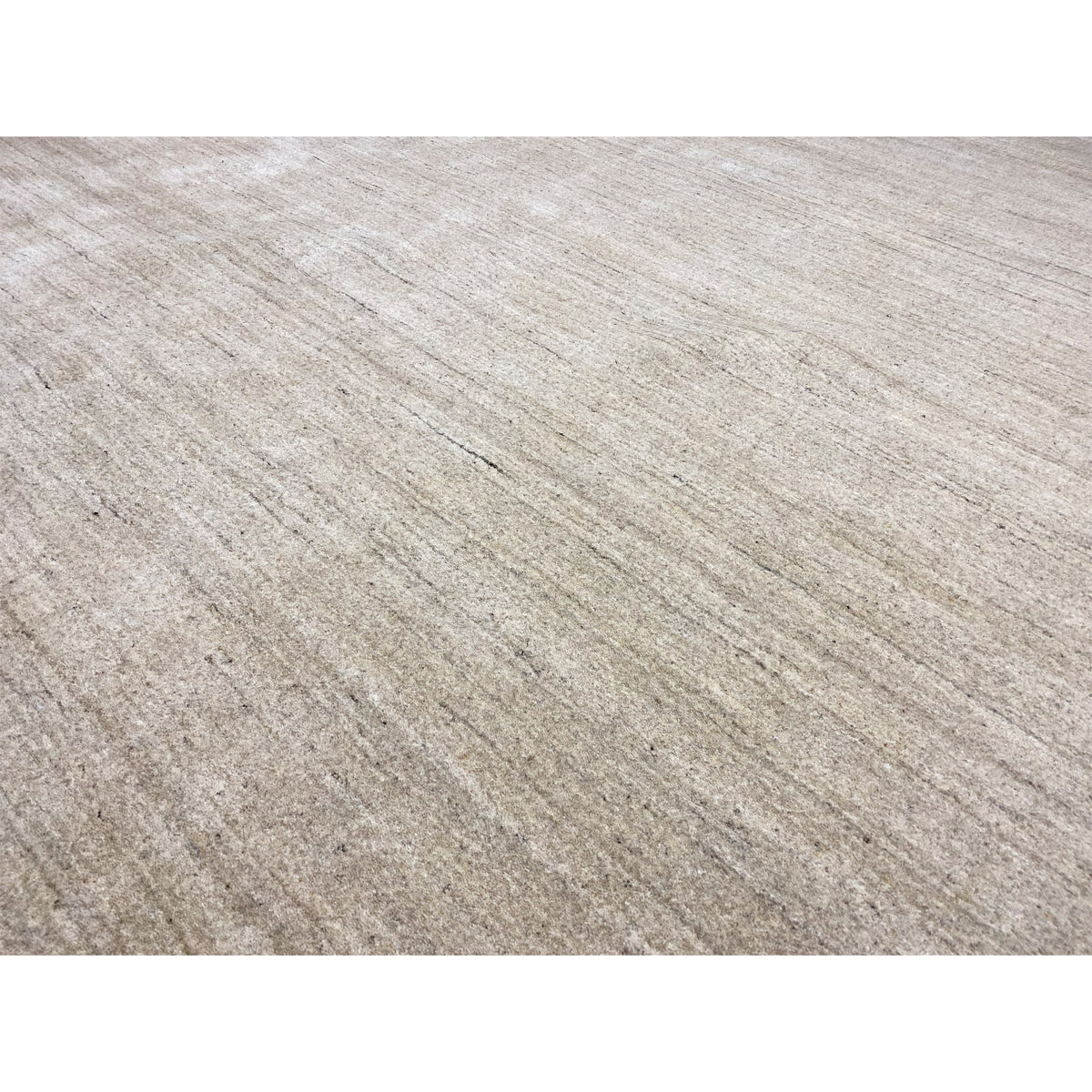 Close-up: beige carpet with a fine linear texture and subtly mottled look