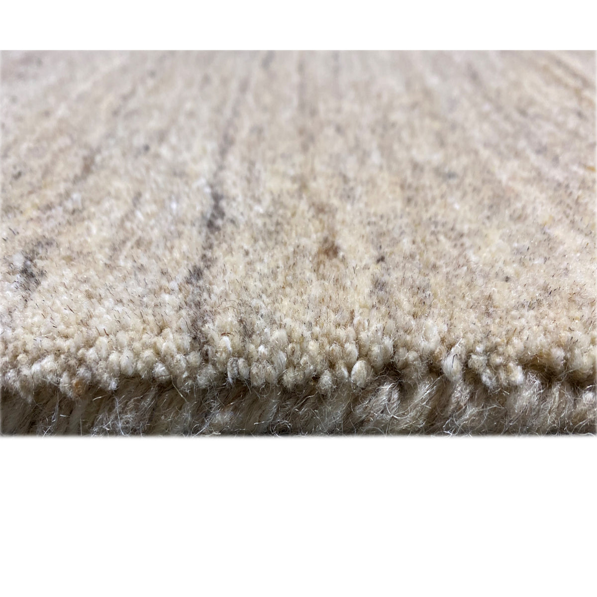 Carpet top in detail: dense short pile with a mottled beige texture