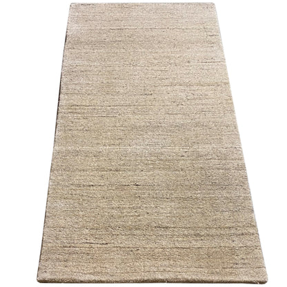 Rectangular rug in light beige with a delicate, wavy line pattern