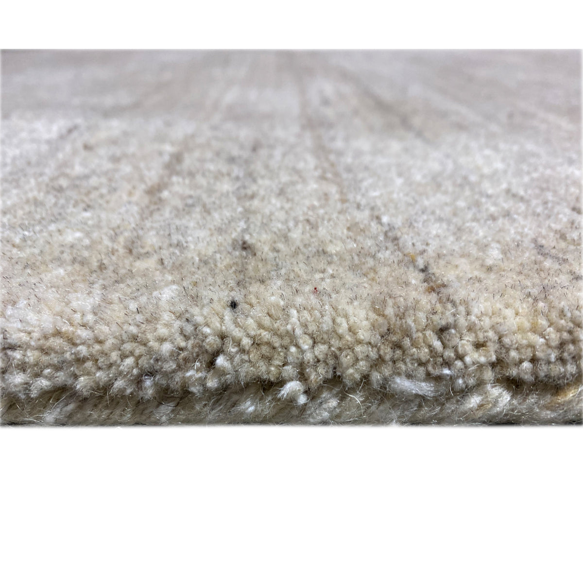 Rug detail: dense pile, beige tones with a subtle pattern