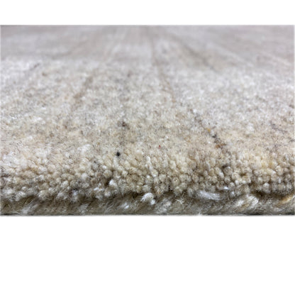 Rug detail: dense pile, beige tones with a subtle pattern