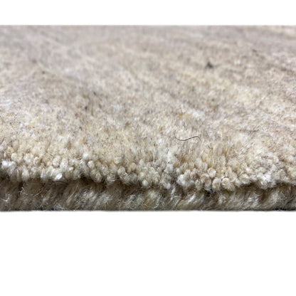 Carpet edge in detail: short pile fibers and multicolored loops, light beige-gray