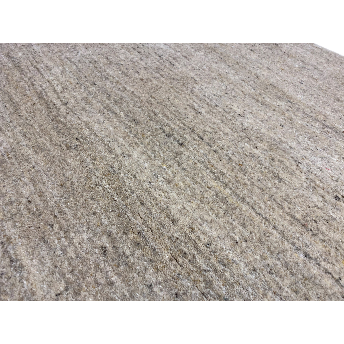 Close-up: beige carpet with a dense, mottled weave and fine dots