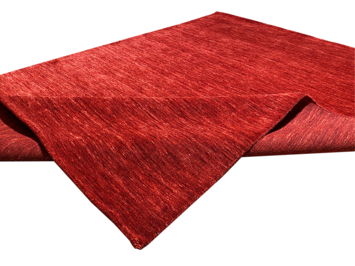 Loom Luri Teppich in Rot, Kurzflor, rechteckig mit sichtbarer Kante in Diagonalansicht.
