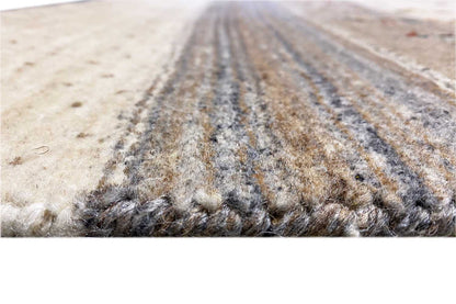 Close-up: beige wool rug with gray threads and short, fringed pile