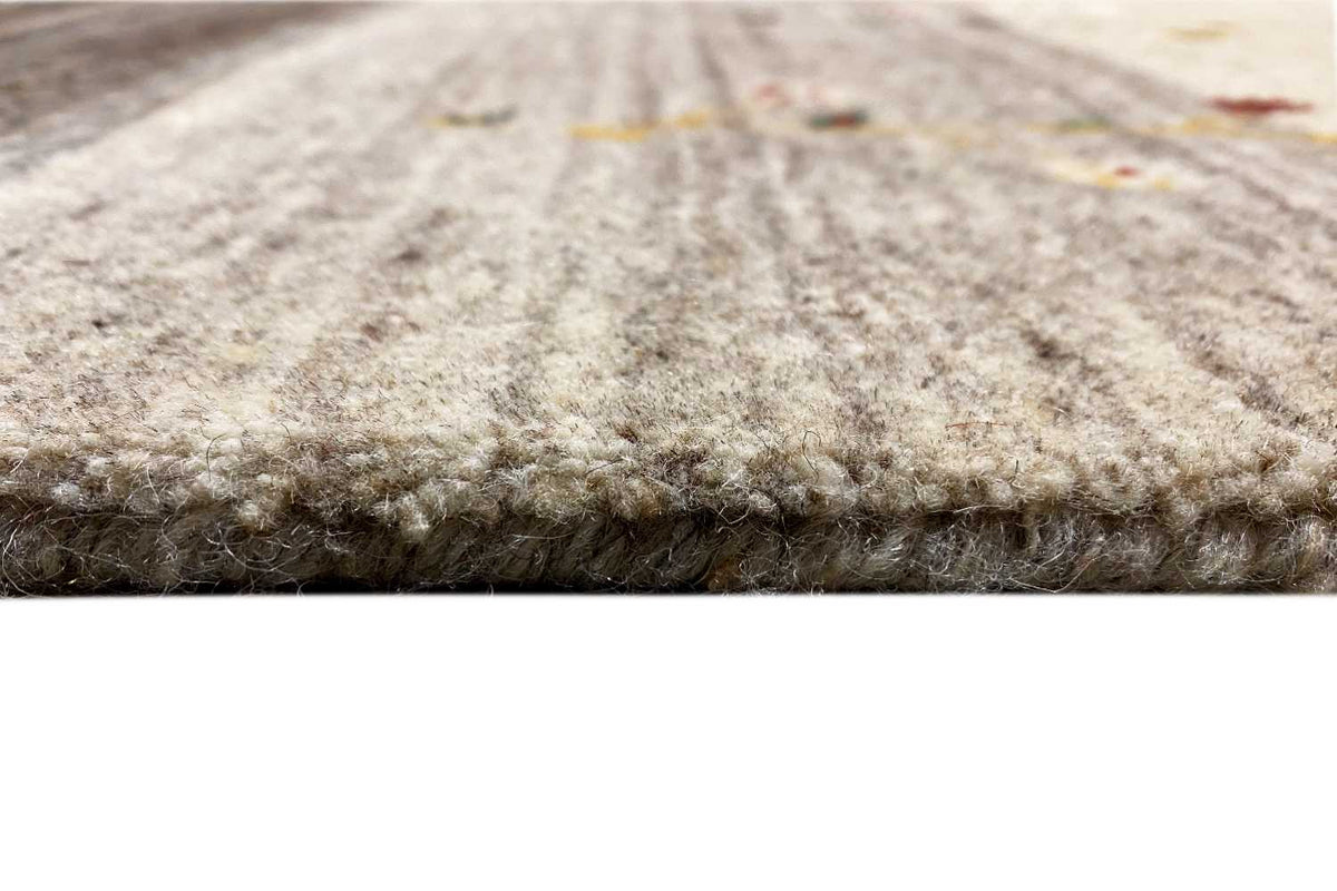 Gabbeh rug close-up: dense beige wool pile at the edge