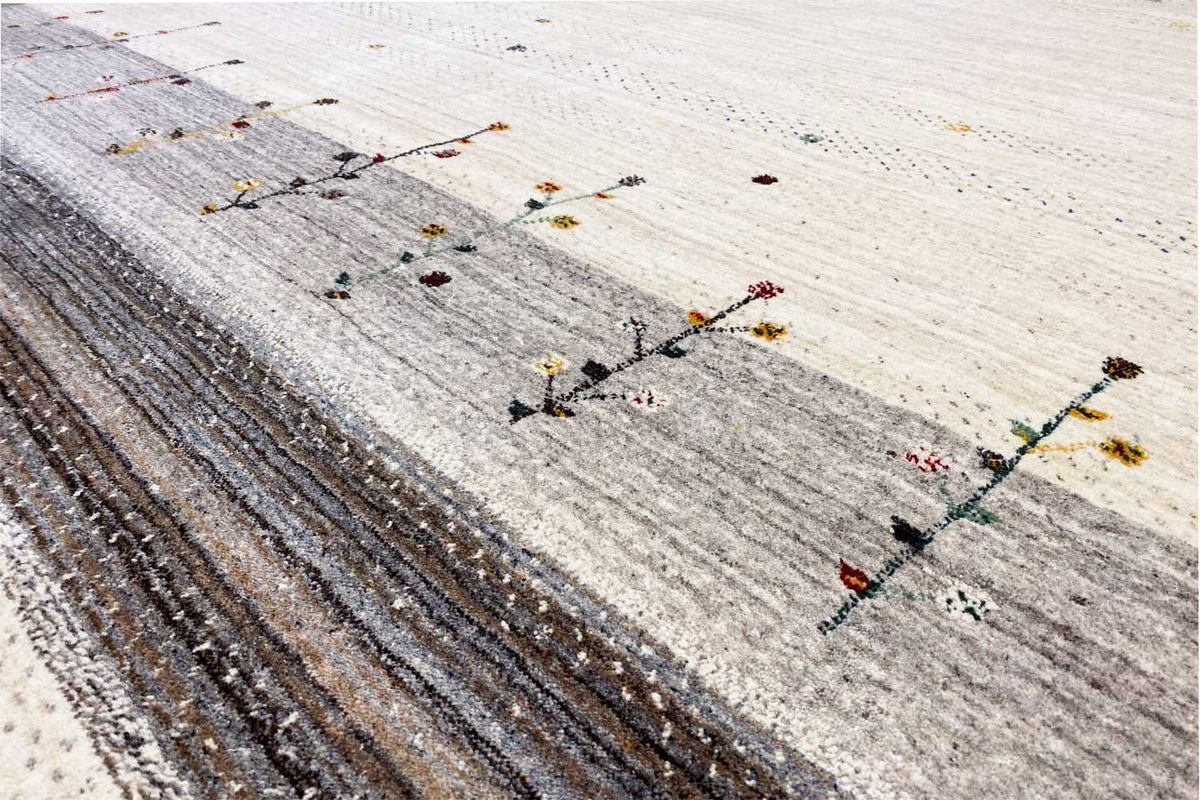 Gabbeh rug detail: dark border with beige dots and colorful cross lines
