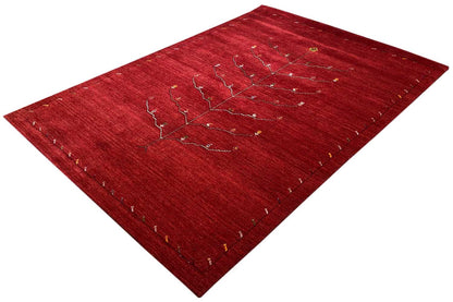 Red Gabbeh rug with a beige and gold tree-vine pattern, diagonal